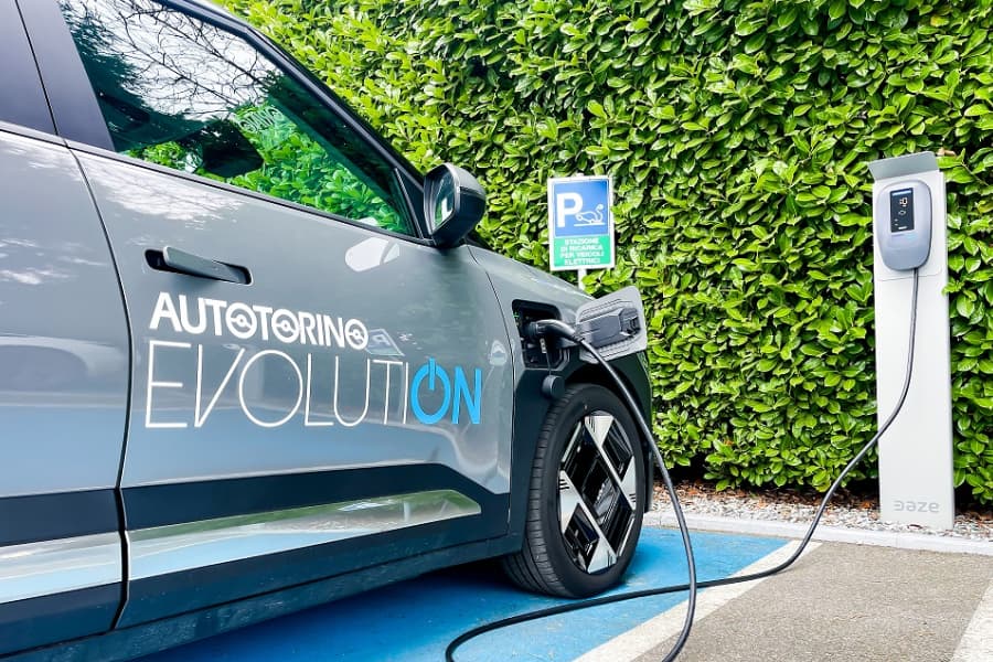 Murales con auto elettrica e scritta “guida il cambiamento”